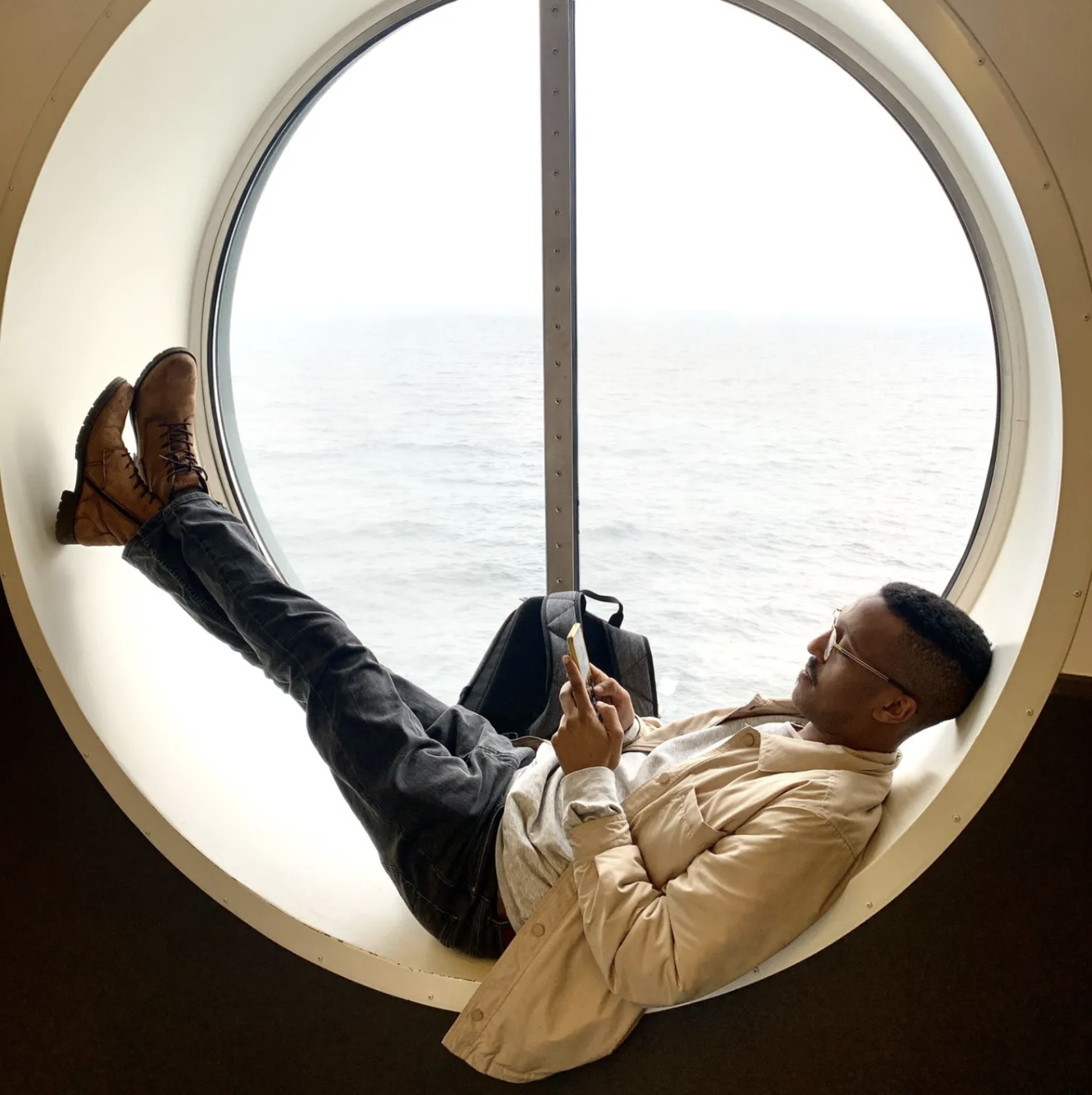 Reading beside a round window overlooking the sea