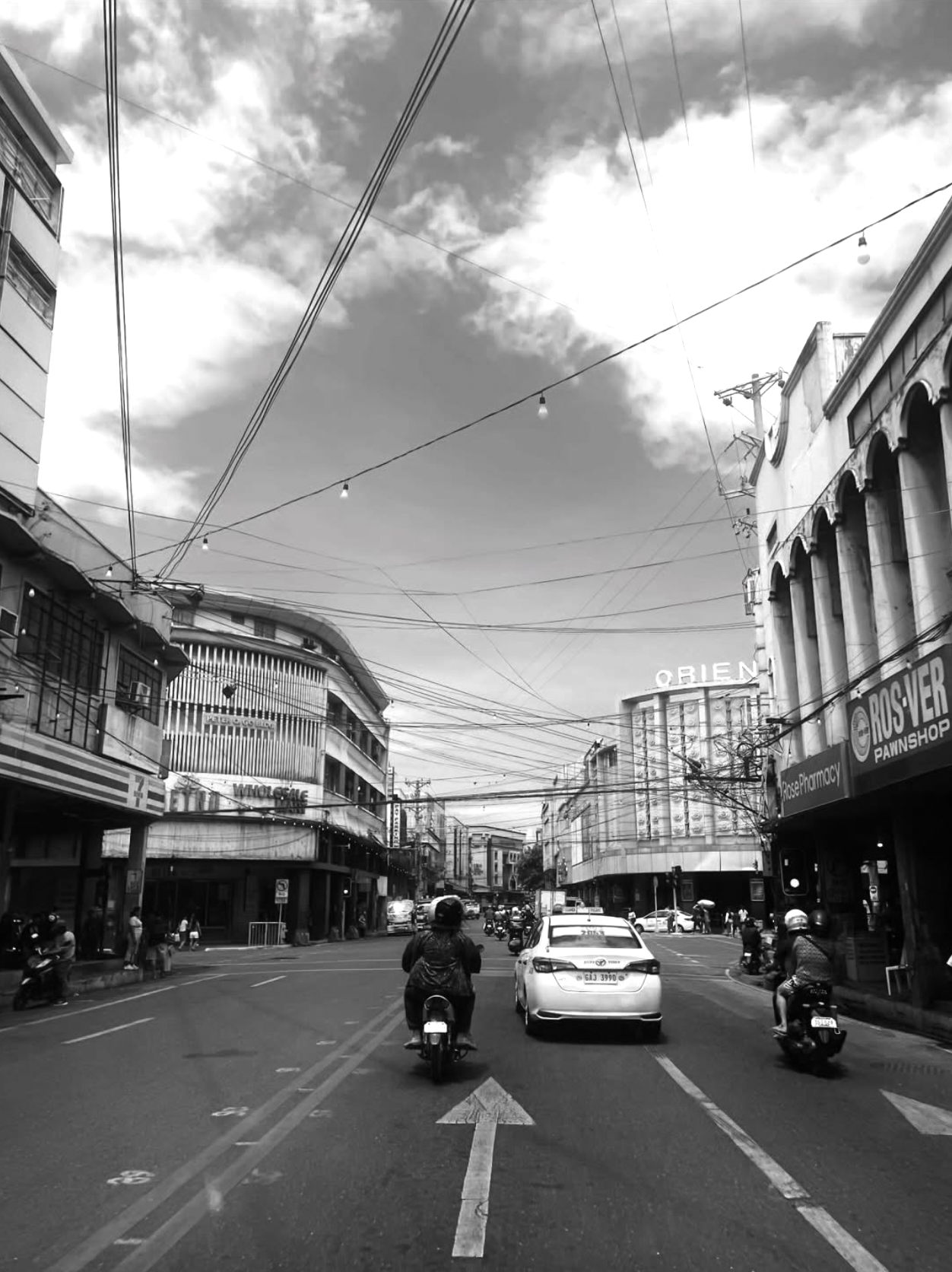 A city street with shops and passing traffic